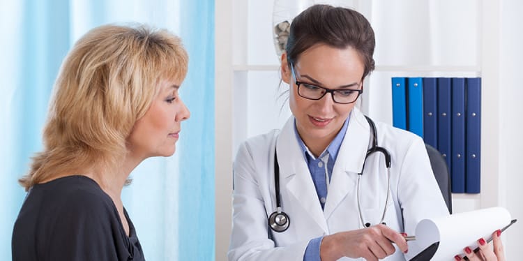 Three camping tents lined up outdoors with trees surrounding